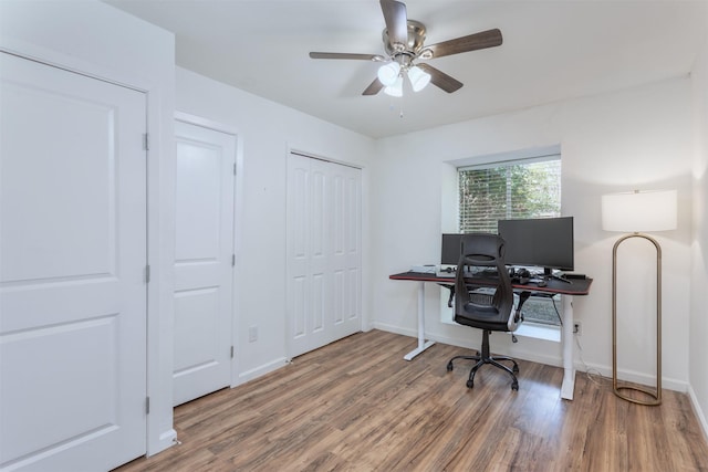 office space with a ceiling fan, baseboards, and wood finished floors