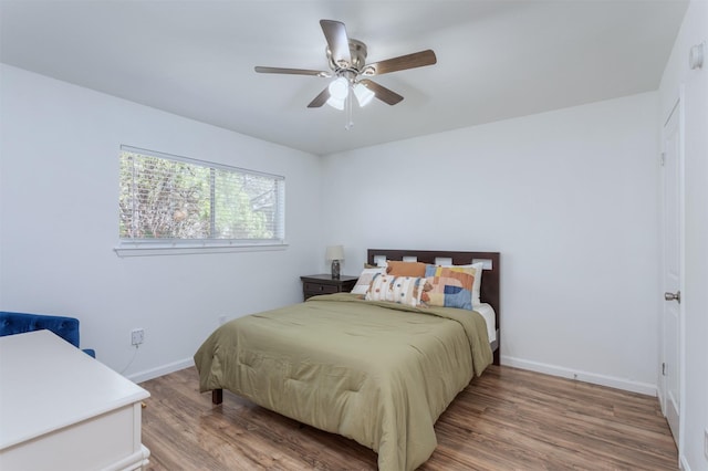 bedroom with ceiling fan, baseboards, and wood finished floors