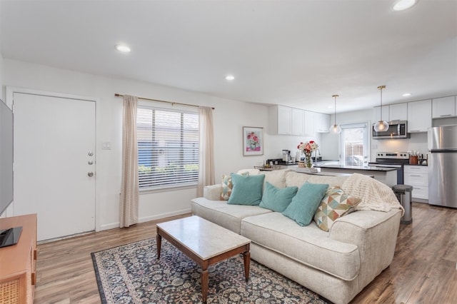 living area with light wood-style floors, recessed lighting, and baseboards