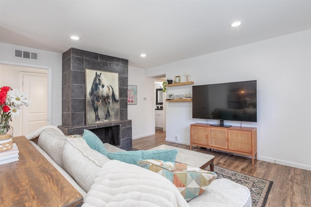 living area with baseboards, wood finished floors, visible vents, and recessed lighting