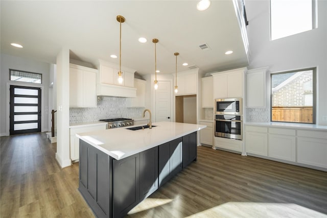 kitchen featuring appliances with stainless steel finishes, white cabinets, a sink, and visible vents