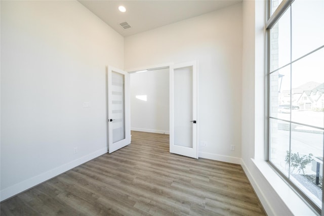 empty room featuring baseboards, visible vents, and a healthy amount of sunlight