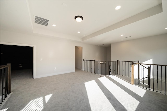 unfurnished room with baseboards, a raised ceiling, visible vents, and recessed lighting