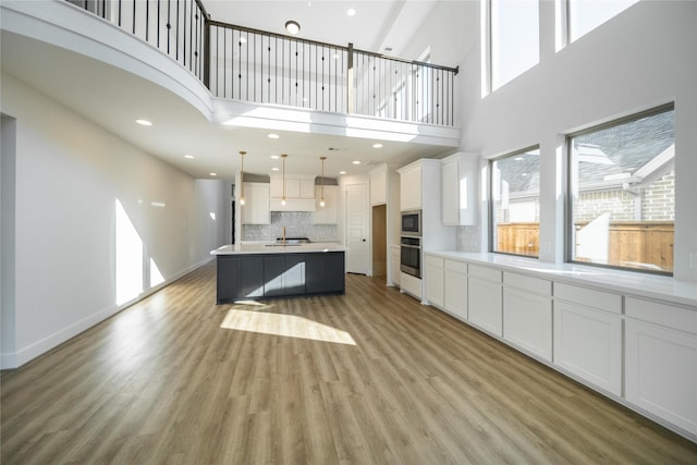 kitchen with light wood-type flooring, appliances with stainless steel finishes, white cabinets, and a sink