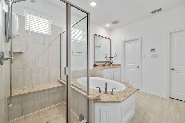 bathroom featuring vanity, a garden tub, visible vents, and a stall shower