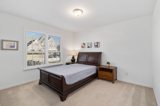 bedroom featuring baseboards and light carpet