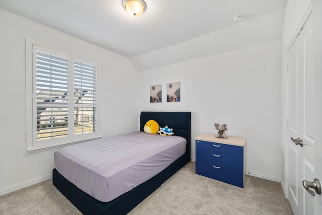 bedroom with a closet, baseboards, carpet, and vaulted ceiling