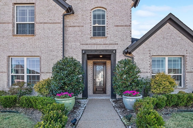 entrance to property featuring brick siding