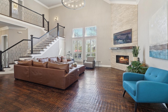 living area featuring ornamental molding, stairway, a fireplace, and baseboards