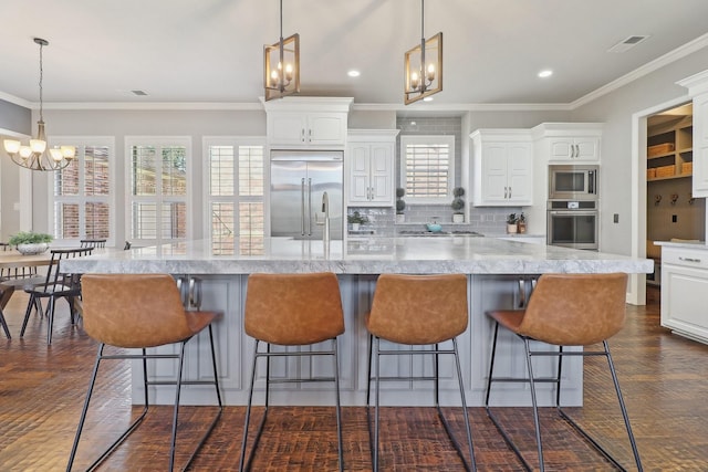 kitchen with built in appliances, plenty of natural light, and white cabinets