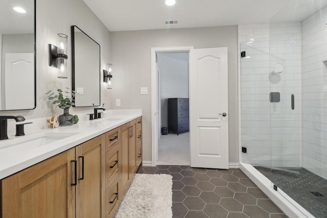 full bathroom with double vanity, a shower stall, visible vents, and a sink