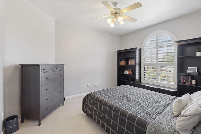 bedroom with light carpet, ceiling fan, and baseboards