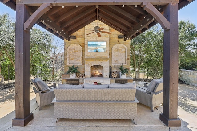 view of patio featuring an outdoor living space with a fireplace and a ceiling fan