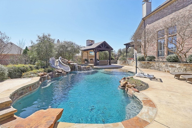 view of pool with a patio area, fence, a water slide, and a gazebo