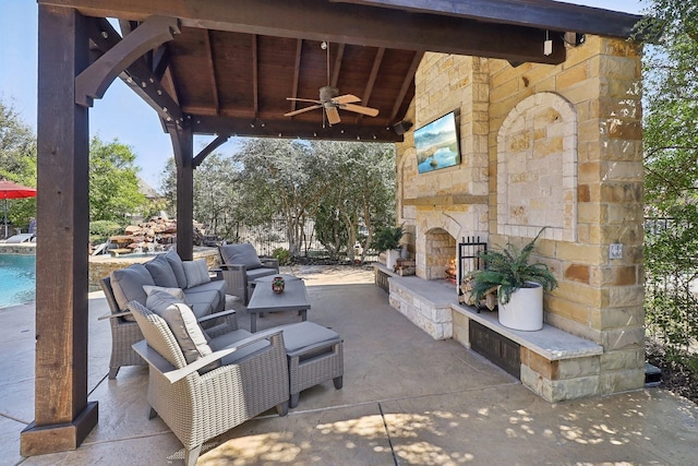 view of patio / terrace featuring a ceiling fan, a gazebo, and an outdoor living space with a fireplace