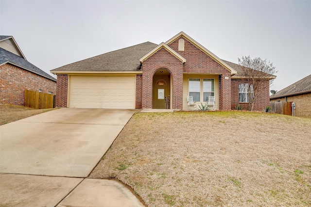 single story home featuring concrete driveway, brick siding, an attached garage, and fence