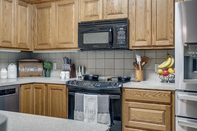 kitchen with a warming drawer, black appliances, tasteful backsplash, and light countertops