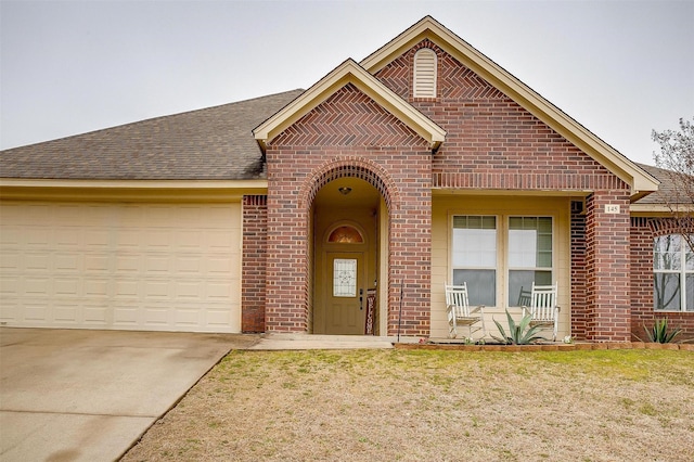 view of front facade featuring a garage, driveway, brick siding, and roof with shingles