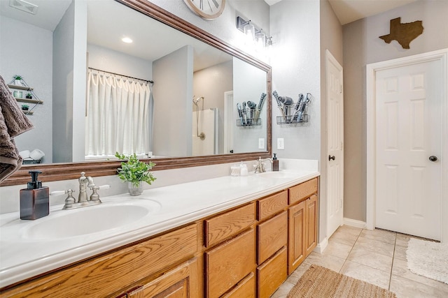 bathroom with double vanity, a shower with curtain, visible vents, and a sink