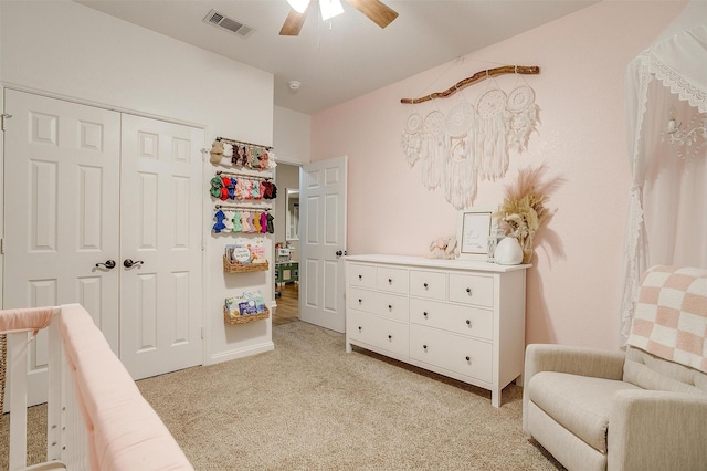 bedroom with light carpet, a ceiling fan, visible vents, and a closet