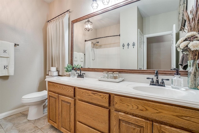 bathroom featuring toilet, double vanity, and a sink