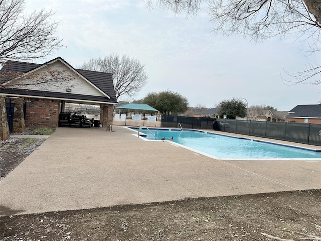 view of swimming pool featuring a patio, fence, and a fenced in pool