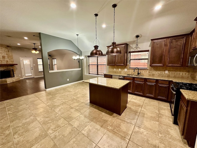 kitchen with a kitchen island, backsplash, vaulted ceiling, stainless steel appliances, and a sink