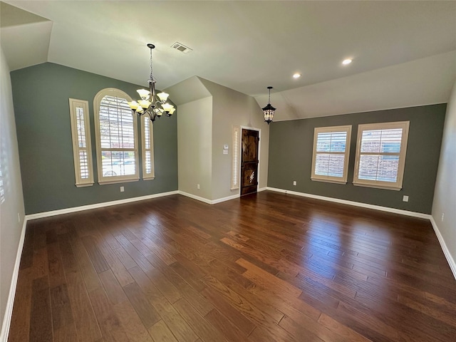 spare room with visible vents, baseboards, vaulted ceiling, dark wood finished floors, and an inviting chandelier