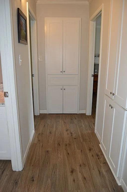 hallway with baseboards and wood finished floors
