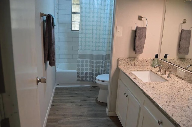 full bathroom with toilet, shower / tub combo, wood finished floors, vanity, and baseboards
