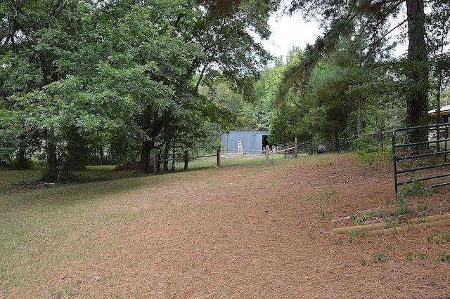 view of yard featuring an outdoor structure and fence