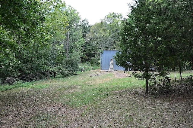 view of yard with a storage shed, an outdoor structure, and fence