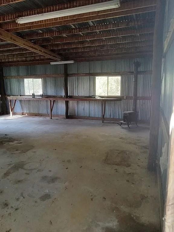 misc room with unfinished concrete floors and metal wall