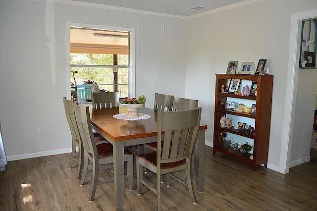 dining space featuring ornamental molding, visible vents, baseboards, and wood finished floors