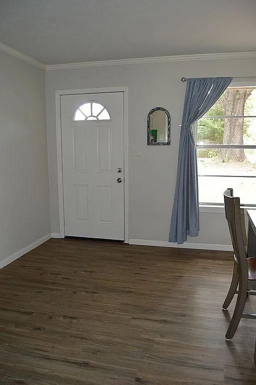 foyer featuring baseboards, dark wood-style flooring, and crown molding