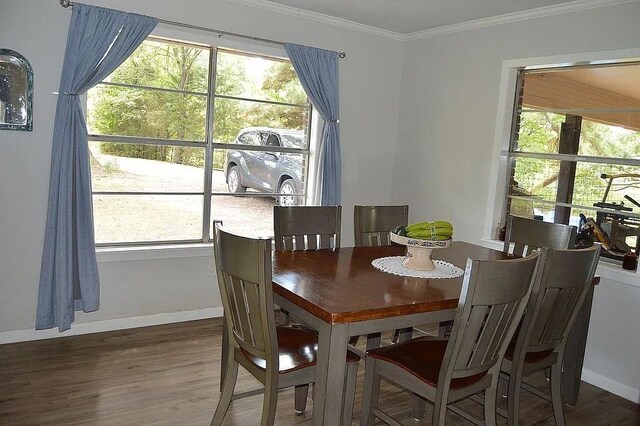 dining space with crown molding, baseboards, and wood finished floors