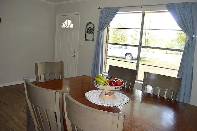 dining space featuring crown molding, baseboards, and wood finished floors