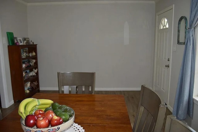 dining area featuring baseboards, crown molding, and wood finished floors