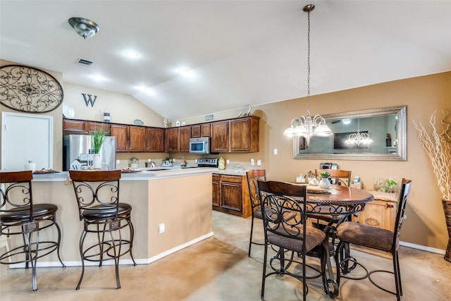 kitchen with stainless steel appliances, visible vents, an inviting chandelier, vaulted ceiling, and a kitchen breakfast bar