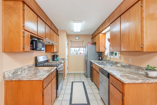 kitchen featuring stainless steel appliances, light countertops, a sink, a textured ceiling, and under cabinet range hood