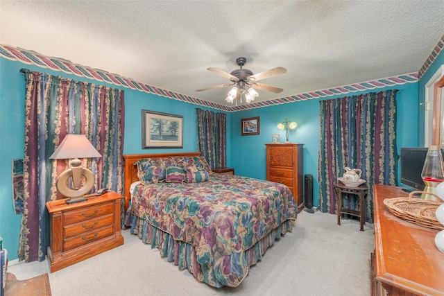 carpeted bedroom featuring a ceiling fan and a textured ceiling