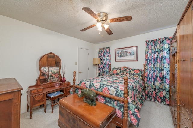 bedroom featuring light carpet, a ceiling fan, and a textured ceiling