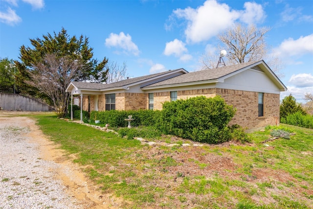 view of front of house featuring fence, a front lawn, and brick siding