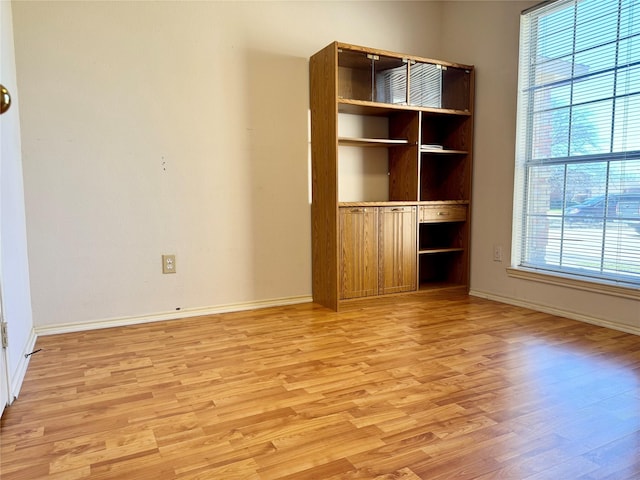 spare room featuring light wood finished floors and baseboards