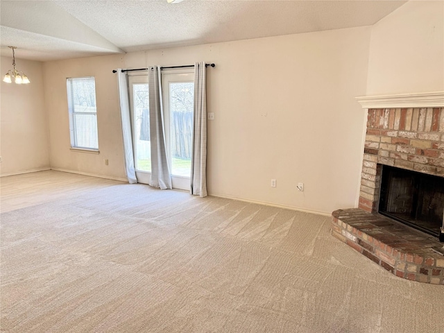 unfurnished living room featuring baseboards, vaulted ceiling, a textured ceiling, carpet floors, and a brick fireplace