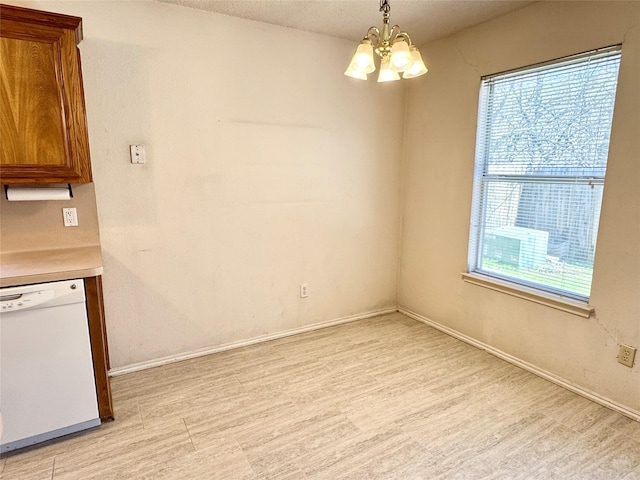 unfurnished dining area featuring a chandelier, light wood-type flooring, and baseboards