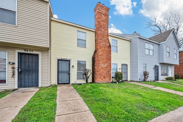 multi unit property with a chimney and a front lawn