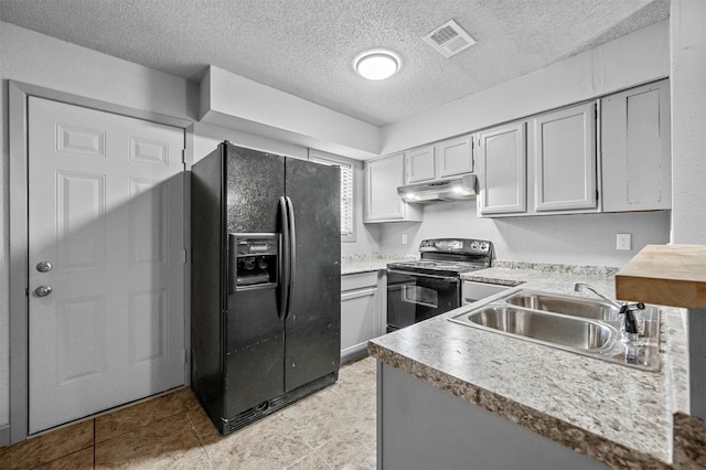 kitchen featuring under cabinet range hood, a sink, visible vents, light countertops, and black appliances