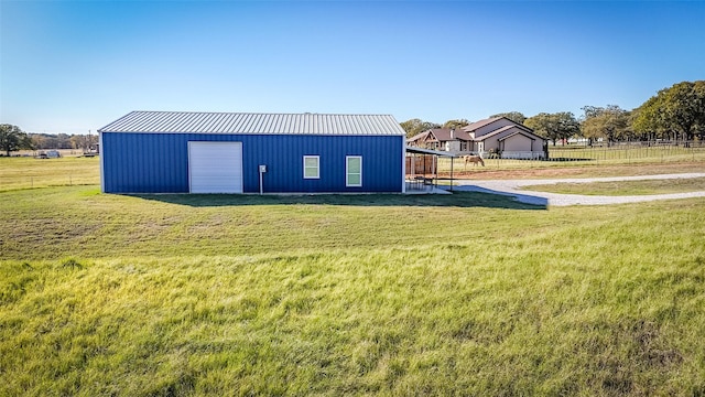 view of pole building featuring fence and a yard