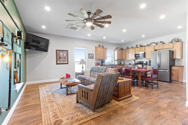 living area with recessed lighting, baseboards, ceiling fan, and light wood finished floors